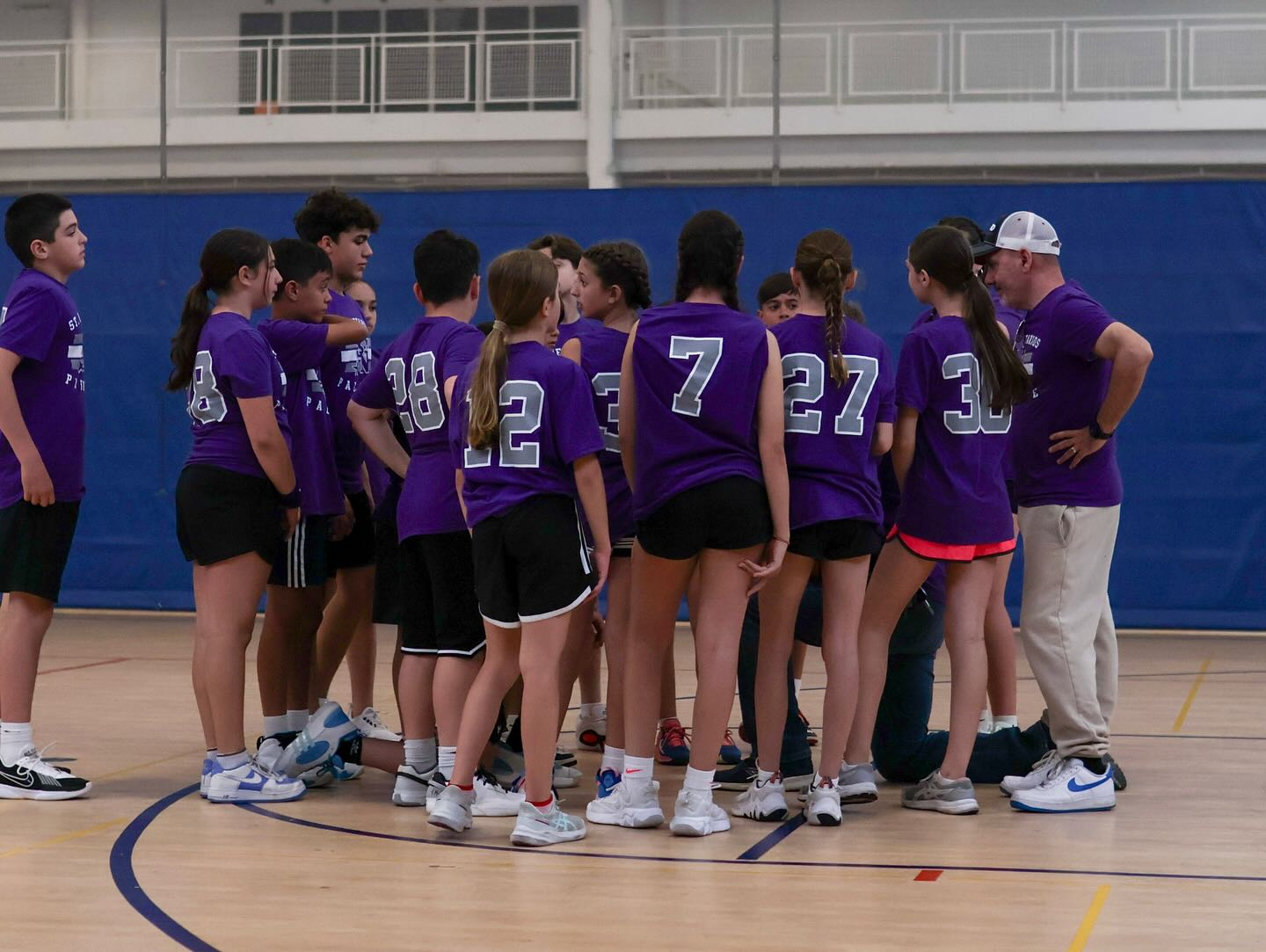 St-Nec-Web-Athletics-A Girls’ basketball team in purple jerseys in the gym
