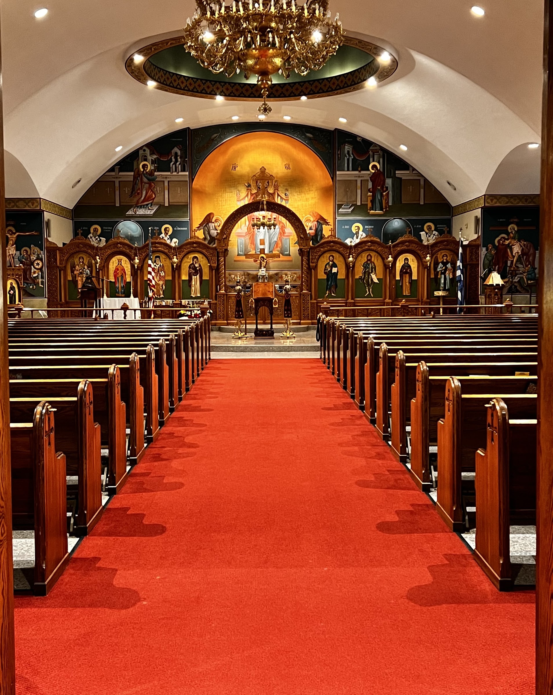 The church aisle with red carpet and chandelier, ready for a wedding